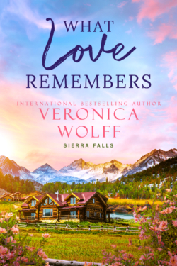 Book cover for What Love Remembers by Veronica Wolff, Sierra Falls series, showing a log cabin in a mountain meadow with pink wildflowers under a pastel sunset sky.